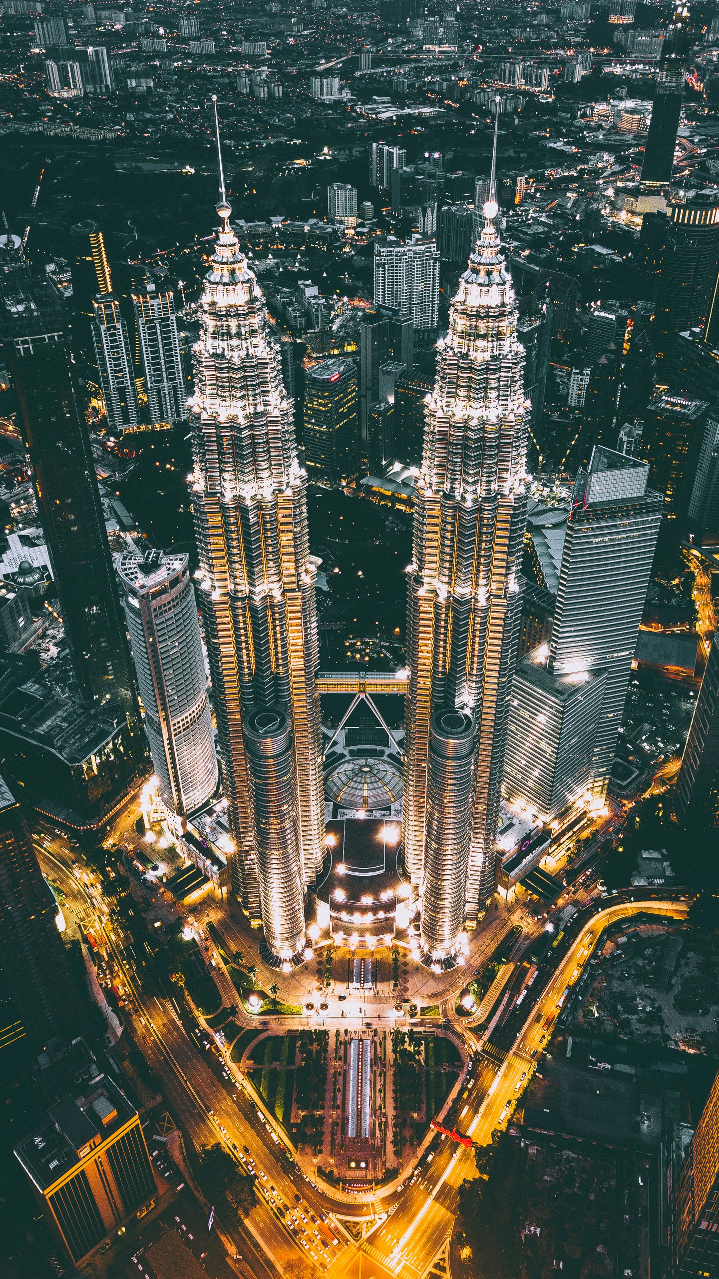 The ultra-modern Petronas Twin Towers in Kuala Lumpur glowing against the evening sky with the city lights below