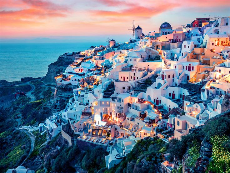 The iconic blue-domed churches and whitewashed houses of Oia, Santorini, overlooking the volcanic caldera and the Aegean Sea